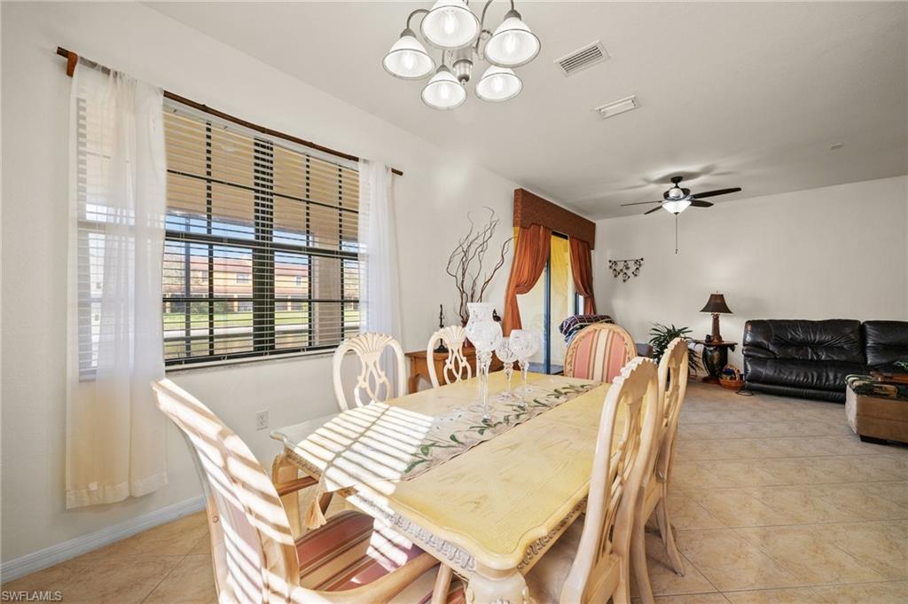 7357 Bristol Circle Naples, FL 34120 - Photo 9 of 44 a view of a dining room with furniture a chandelier and wooden floor