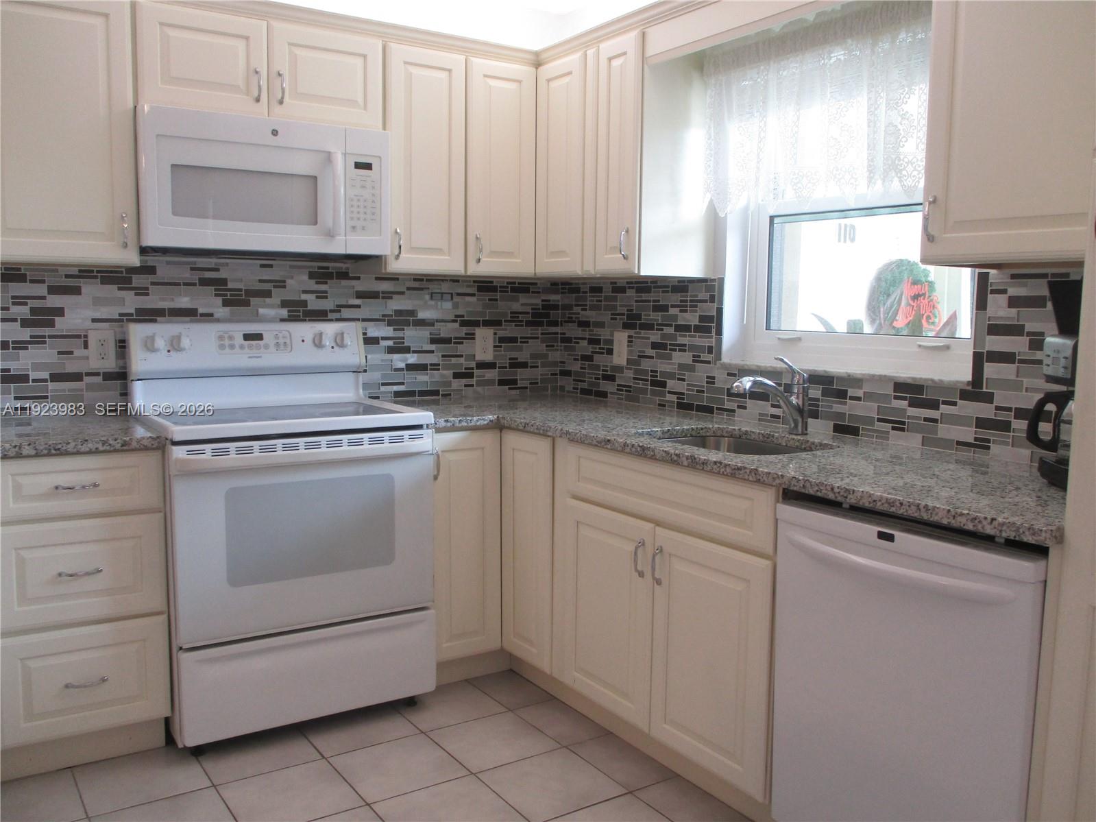 6531 Southeast Federal Highway, Unit D 112 Stuart, FL 34997 - Photo 1 of 33 A BRIGHT KITCHEN WITH GRANITE COUNTERTOPS, CREAM COLORED CABINETS & WHITE APPLIANCES