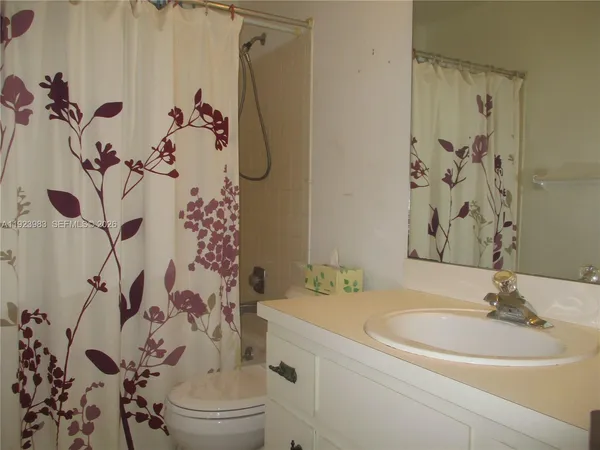 a bathroom with a sink and mirror with toilet