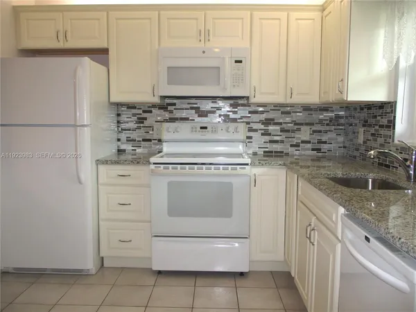 a kitchen with cabinets appliances and a sink
