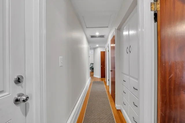 a view of a hallway with wooden floor and staircase