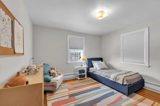 a bedroom with a bed and a dresser next to a window