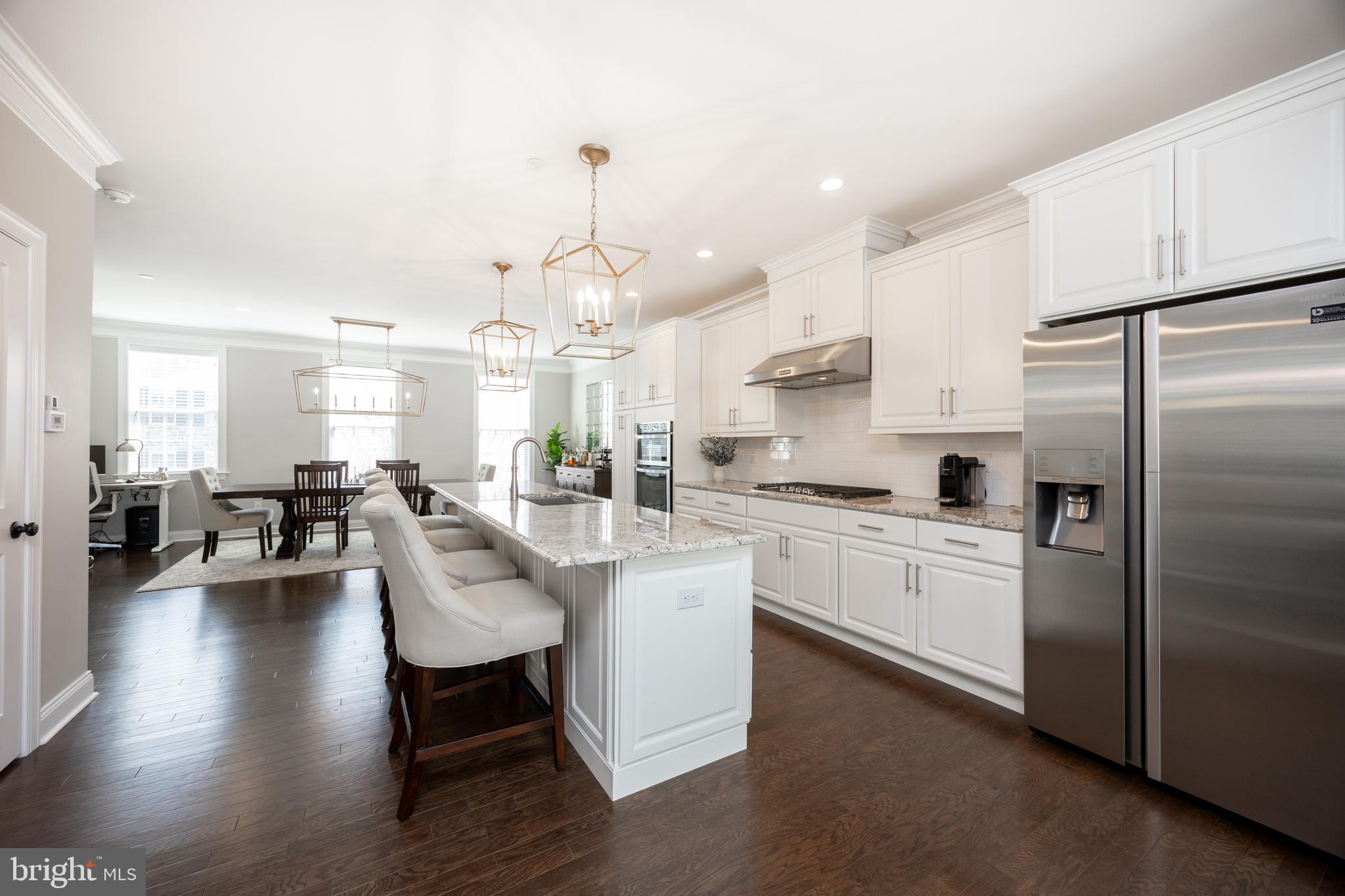 205 Murray Lane Springfield, PA 19064 - Photo 16 of 37 a large white kitchen with lots of counter space dining table and stainless steel appliances