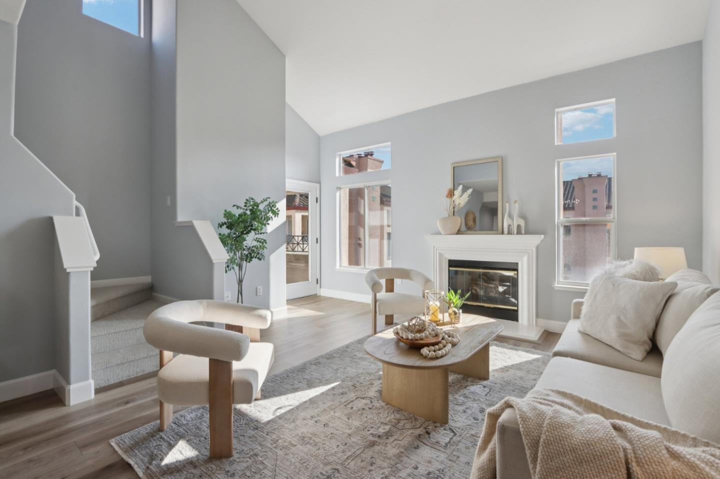 a living room with furniture a fireplace and a potted plant