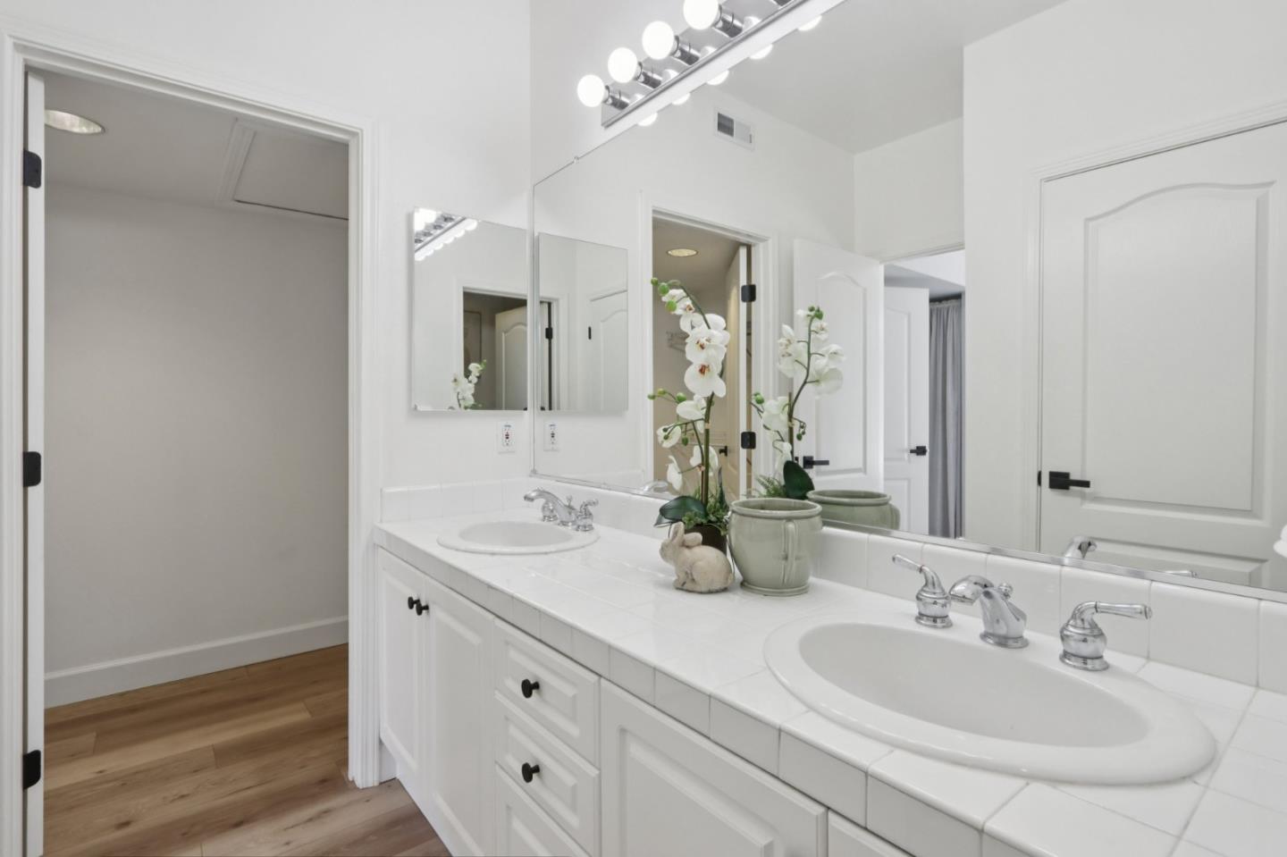 1951 O'Farrell Street, Unit 404 San Mateo, CA 94403 - Photo 18 of 28 a bathroom with double vanity sinks and a mirror