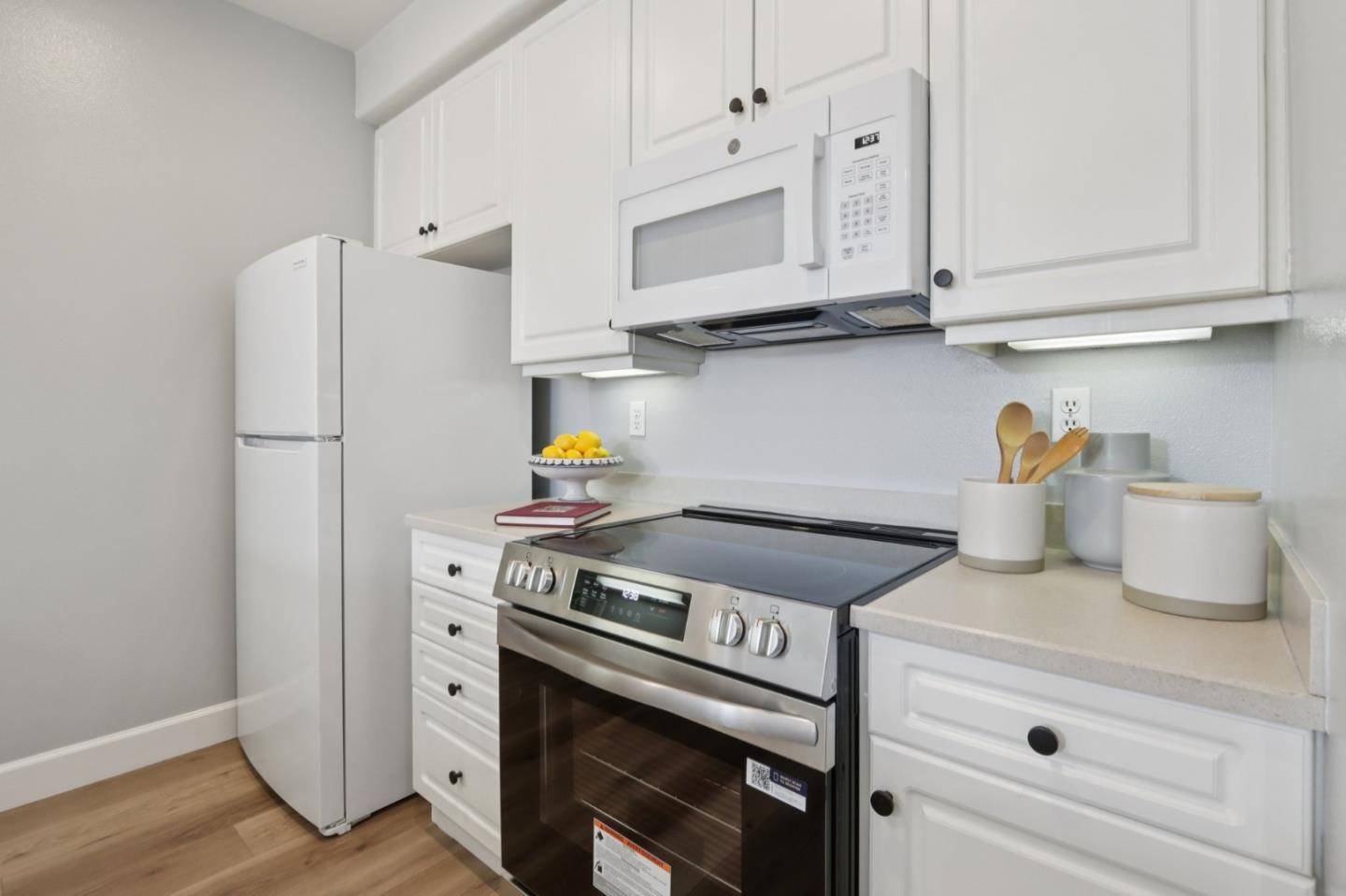 1951 O'Farrell Street, Unit 404 San Mateo, CA 94403 - Photo 10 of 28 a kitchen with stainless steel appliances granite countertop white cabinets and a stove