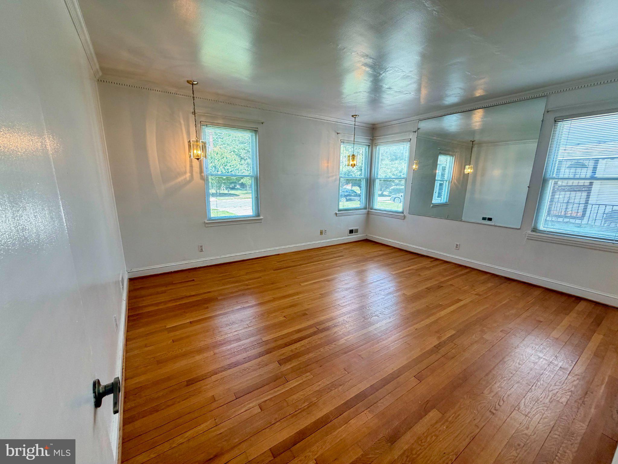 6318 Winner Avenue Baltimore, MD 21215 - Photo 38 of 75 an empty room with wooden floor and windows