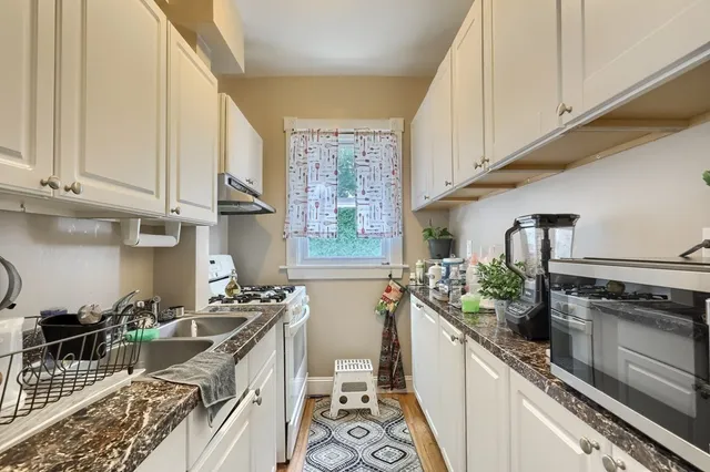 a kitchen with stainless steel appliances a stove a sink and cabinets