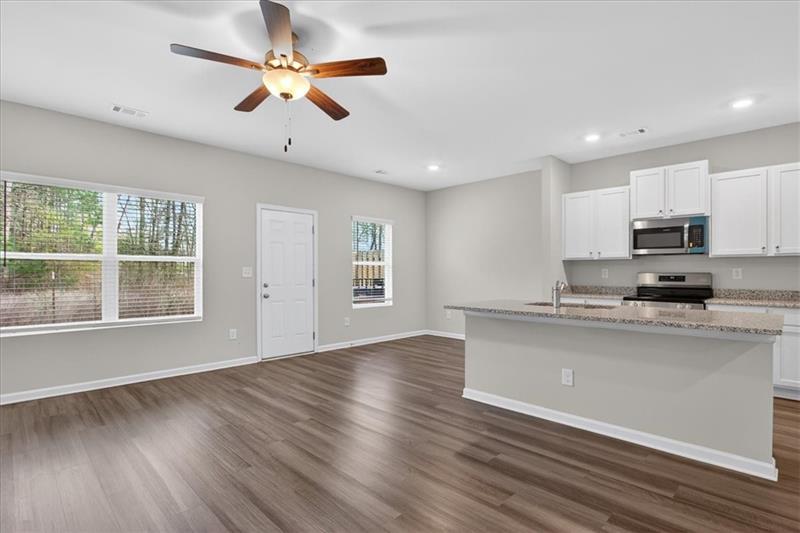 136 Brexley Drive Calhoun, GA 30701 - Photo 12 of 48 a kitchen with stainless steel appliances granite countertop a stove a refrigerator a sink a microwave oven with wooden floor and cabinets
