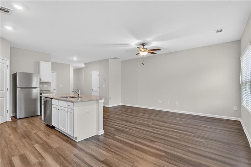 136 Brexley Drive Calhoun, GA 30701 - Photo 14 of 48 a kitchen with stainless steel appliances granite countertop a stove top oven a refrigerator with white cabinets and wooden floor