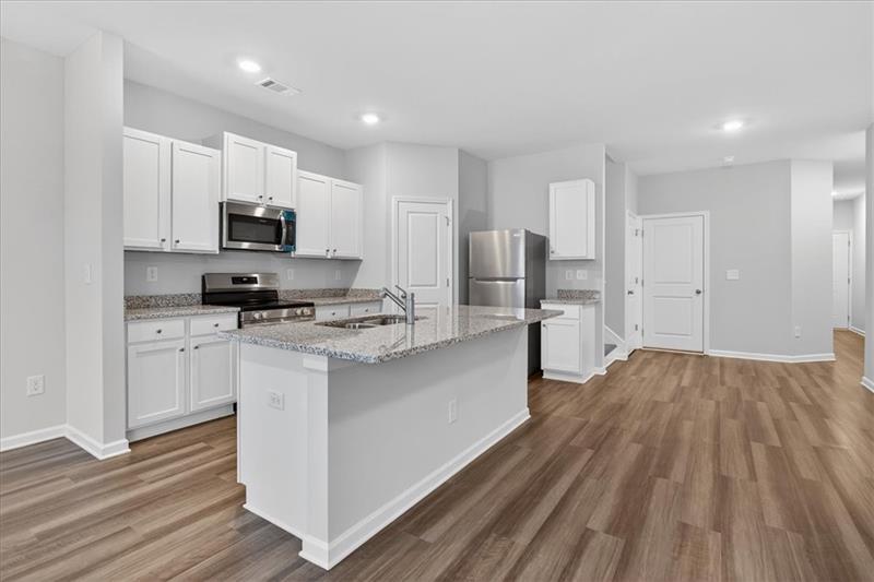 136 Brexley Drive Calhoun, GA 30701 - Photo 15 of 48 a kitchen with kitchen island white cabinets and stainless steel appliances