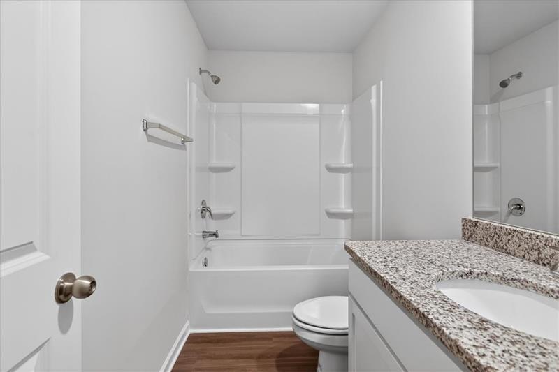 136 Brexley Drive Calhoun, GA 30701 - Photo 39 of 48 a bathroom with a granite countertop bathtub sink vanity mirror and toilet