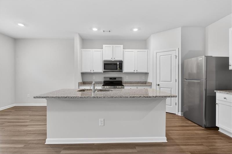 136 Brexley Drive Calhoun, GA 30701 - Photo 10 of 48 a kitchen with stainless steel appliances granite countertop a stove a sink and a refrigerator