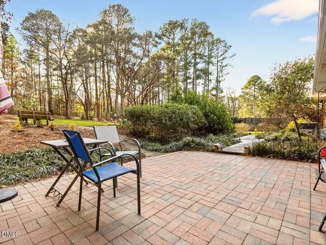 a backyard of a house with table and chairs