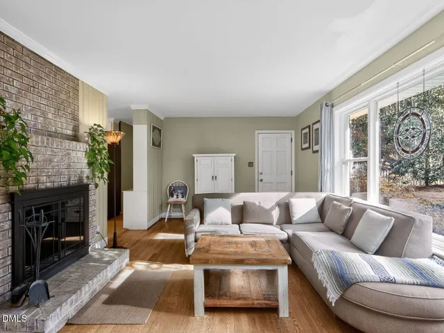 a living room with furniture a fireplace and a large window