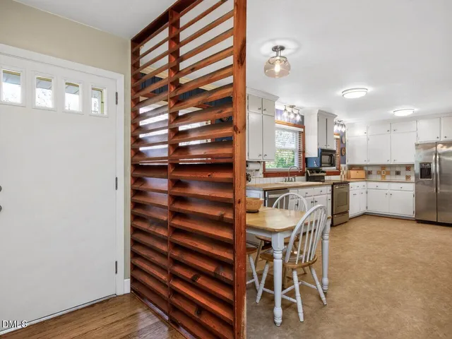 a kitchen with a table chairs and a refrigerator