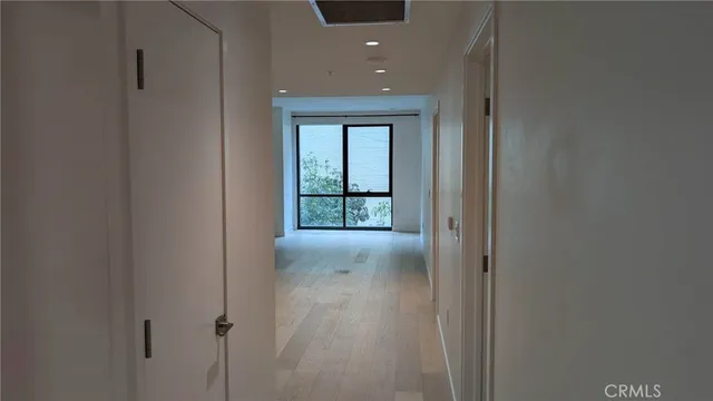 a view of a hallway with wooden floor and a window