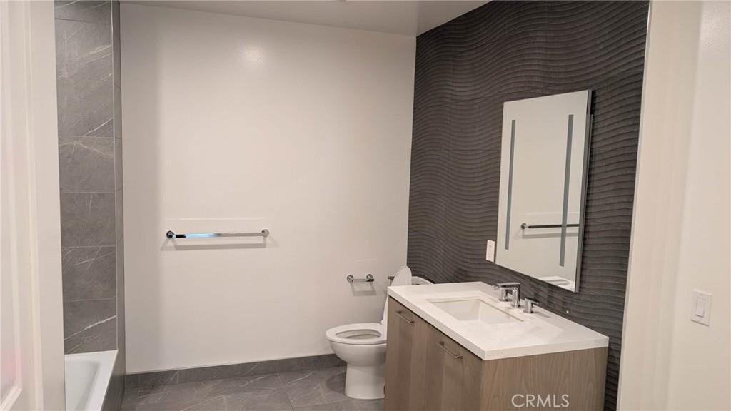 400 South Broadway, Unit 922 Los Angeles, CA 90013 - Photo 10 of 12 a bathroom with a toilet a sink and mirror