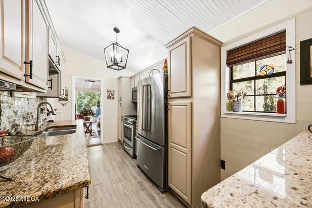 a view of a kitchen with refrigerator and wooden floor