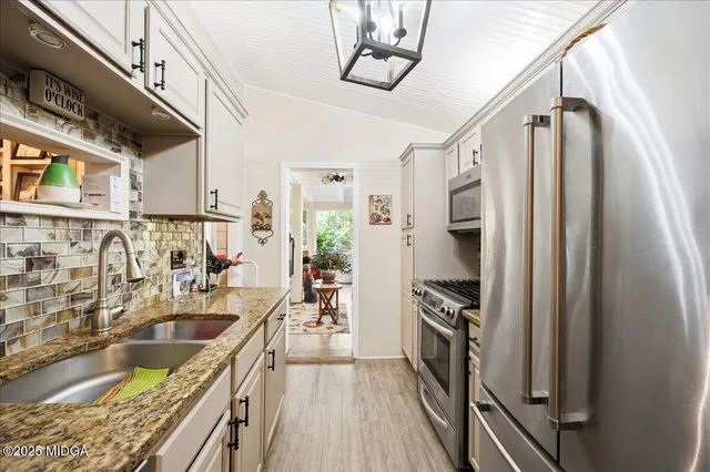 a kitchen with stainless steel appliances granite countertop a sink stove and refrigerator