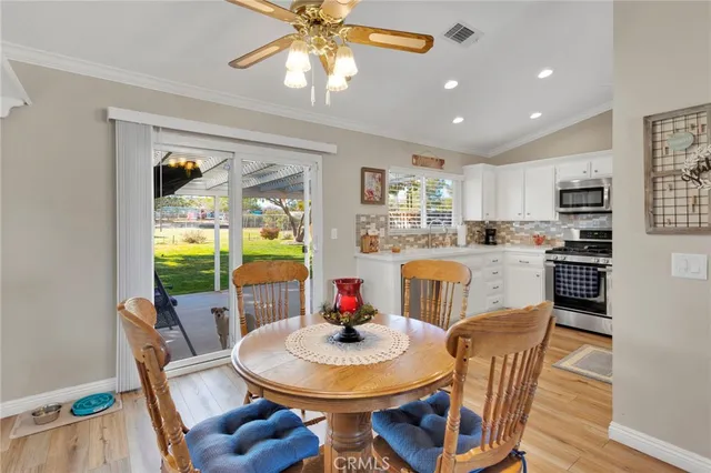 a view of a dining room with furniture a kitchen and chandelier