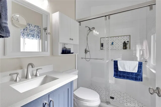 a bathroom with a sink toilet a mirror a vanity and shower