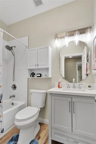 a bathroom with a sink vanity mirror bathtub and toilet