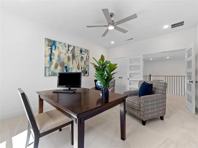 an empty room with windows and ceiling fan