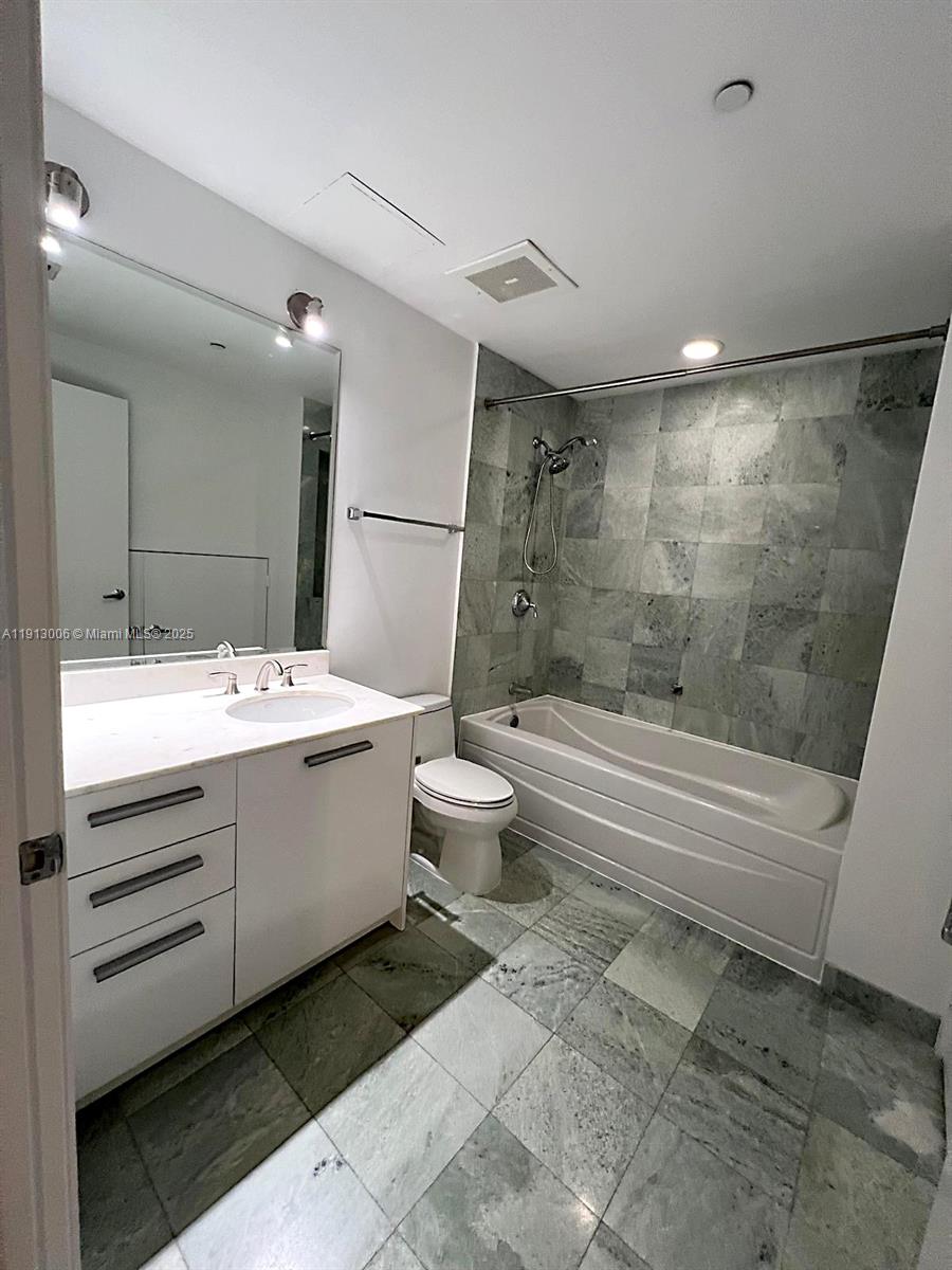 1060 Brickell Avenue, Unit 1007 Miami, FL 33131 - Photo 13 of 14 a bathroom with a sink toilet and shower