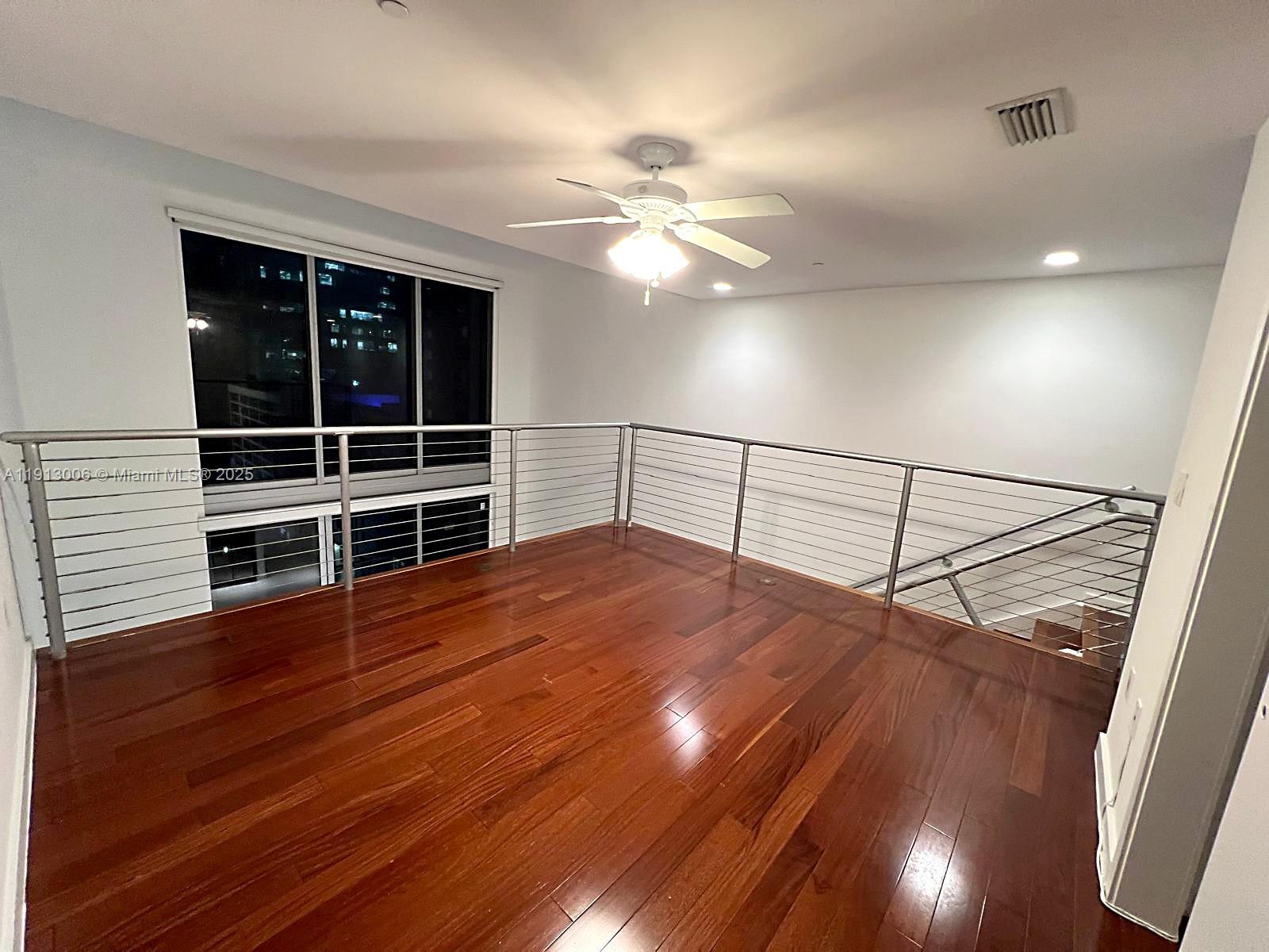 1060 Brickell Avenue, Unit 1007 Miami, FL 33131 - Photo 7 of 14 a view of a room with wooden floor and fan