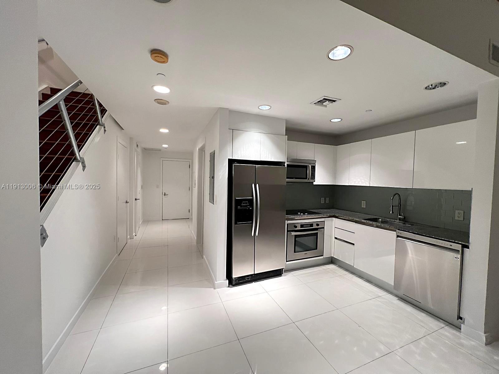 1060 Brickell Avenue, Unit 1007 Miami, FL 33131 - Photo 9 of 14 a large kitchen with a refrigerator and a stove top oven