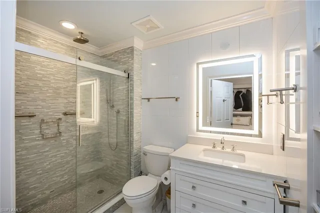 a bathroom with a sink a toilet a mirror and shower