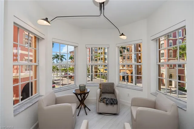 a living room with furniture large window and wooden floor
