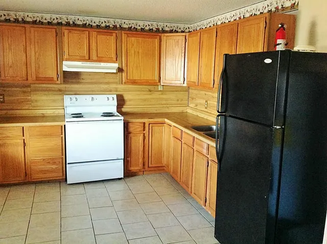 a kitchen with a refrigerator and cabinets
