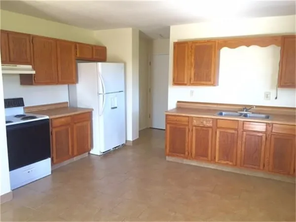 a kitchen with stainless steel appliances granite countertop a refrigerator a sink a stove with wooden cabinets