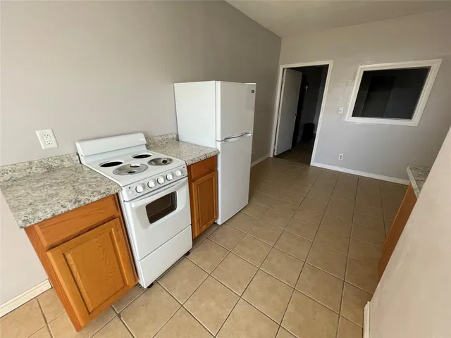 a kitchen with stainless steel appliances granite countertop a stove a refrigerator and a cabinets