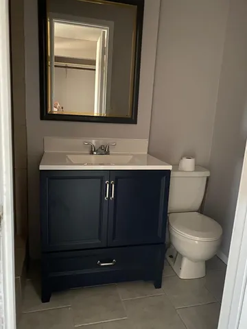 a bathroom with a toilet sink and mirror