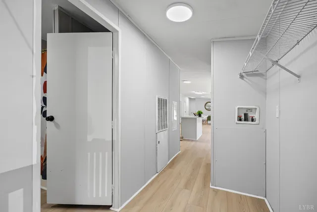 a view of a hallway with wooden floor and closet
