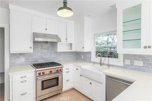 a kitchen with white cabinets and appliances