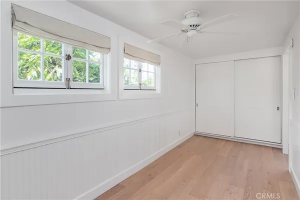 an empty room with a window and a ceiling fan
