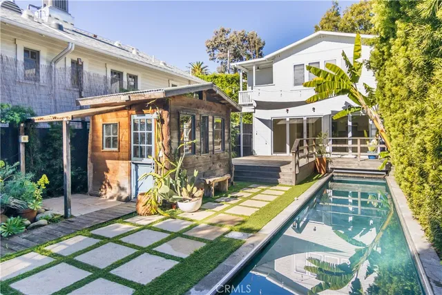 a view of a house with backyard water fountain and sitting area