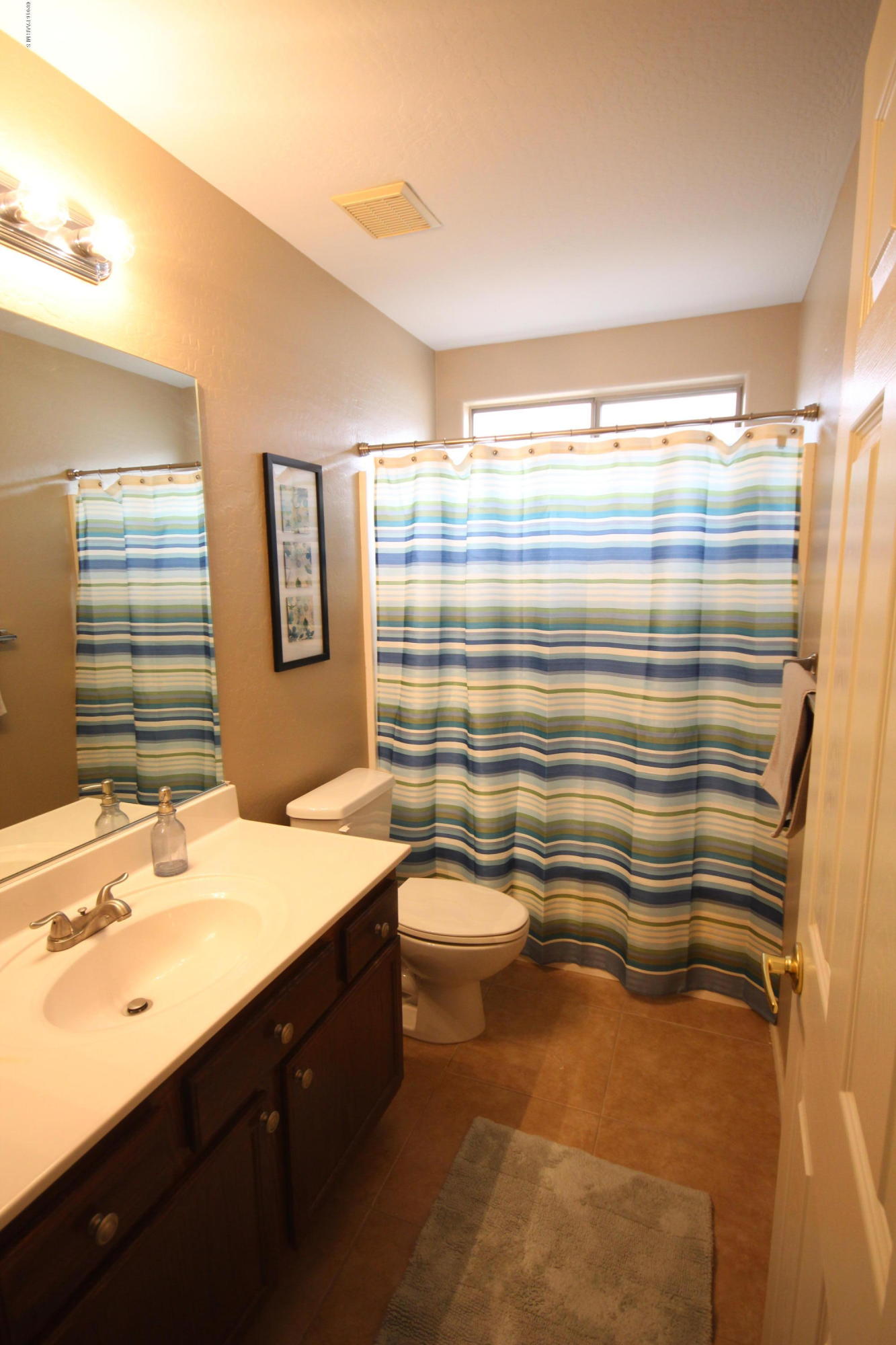 7449 East Plateau Ridge Road Prescott Valley, AZ 86315 - Photo 13 of 17 a bathroom with a sink a mirror and a shower