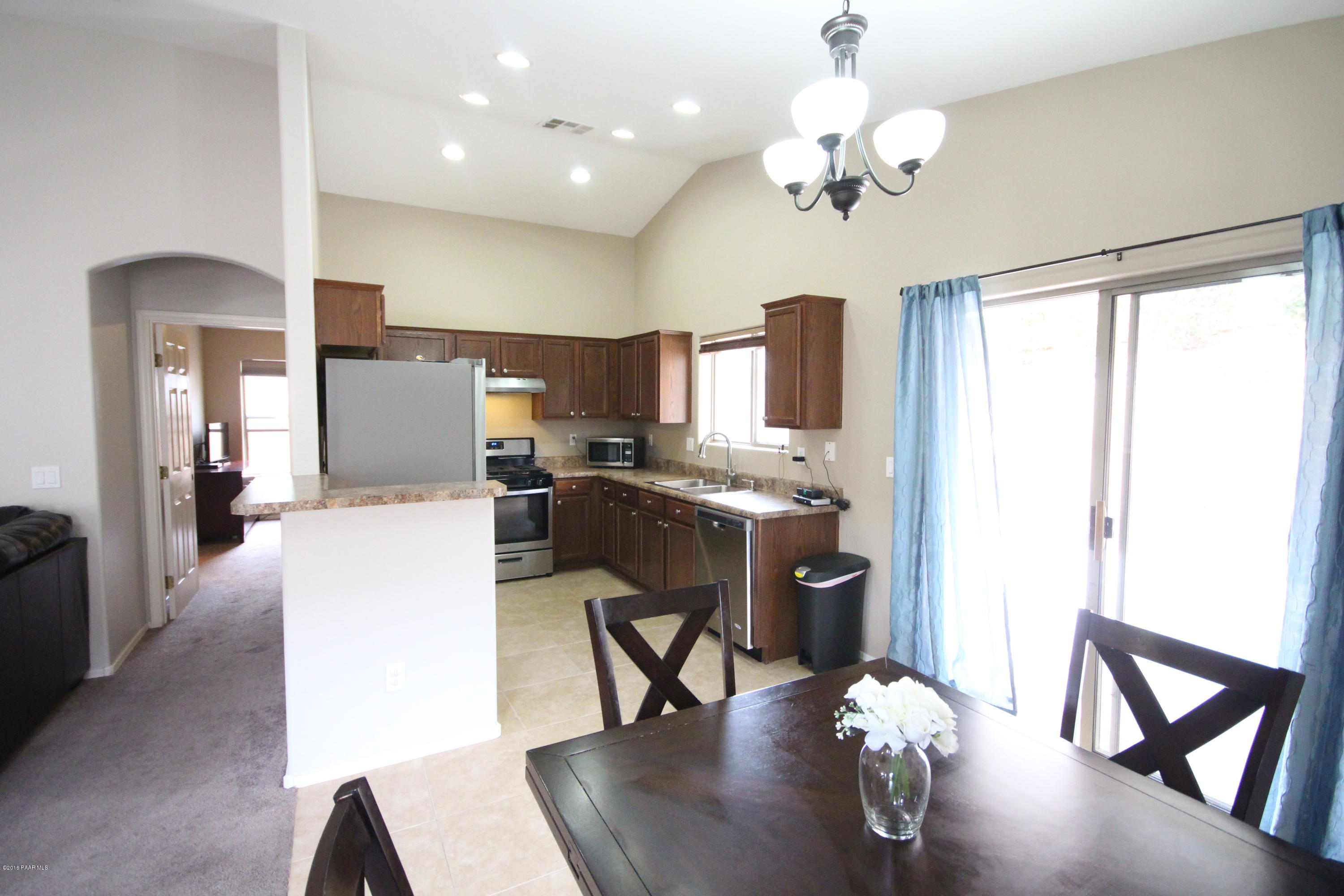 7449 East Plateau Ridge Road Prescott Valley, AZ 86315 - Photo 6 of 17 a view of a dining room and livingroom with furniture wooden floor a chandelier