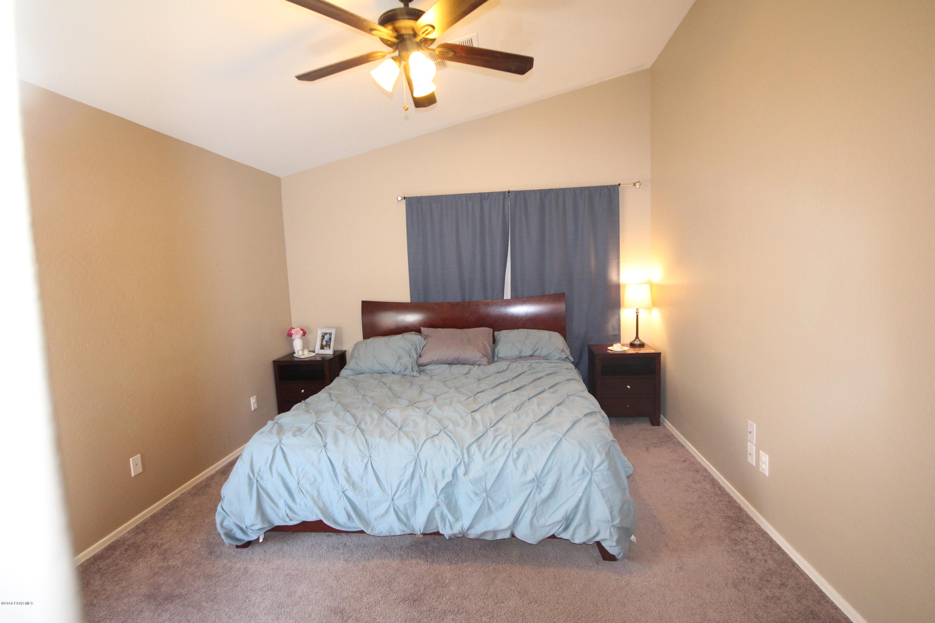 7449 East Plateau Ridge Road Prescott Valley, AZ 86315 - Photo 9 of 17 a bedroom with a bed and a chandelier