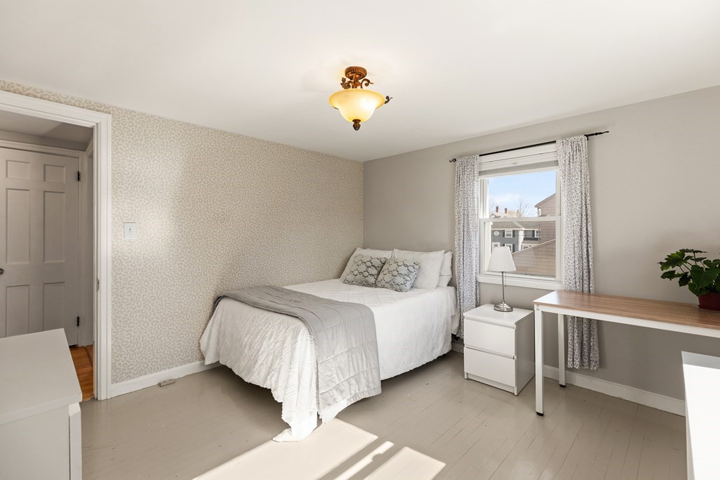 38 Magnolia Road Milton, MA 02186 - Photo 13 of 34 a bedroom with a bed and a chandelier