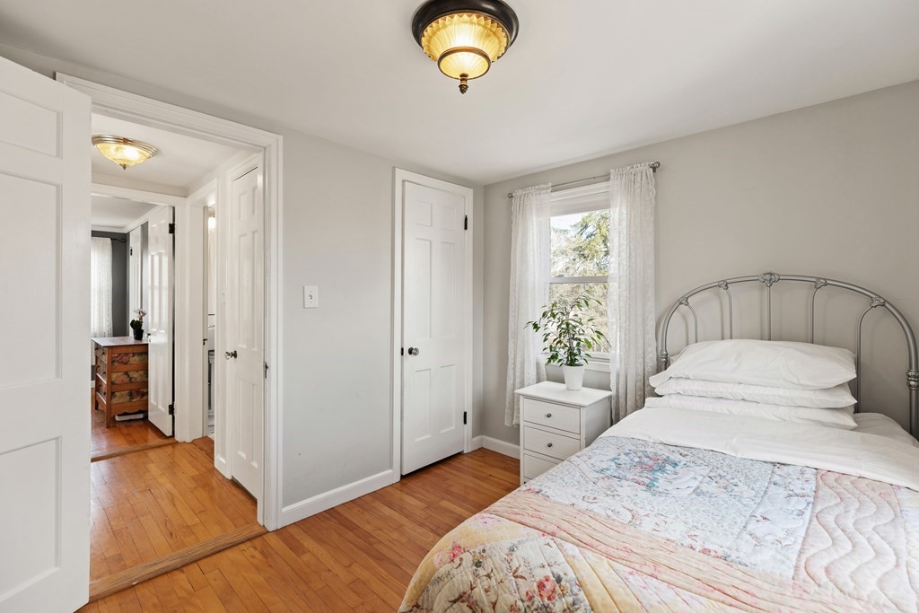 38 Magnolia Road Milton, MA 02186 - Photo 17 of 34 a bedroom with a bed and a chandelier