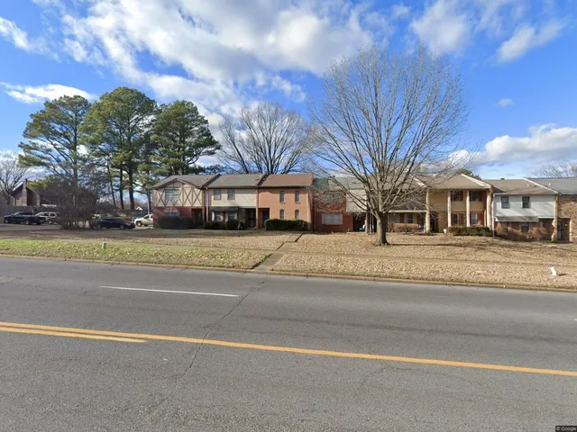 a front view of residential houses with yard and trees