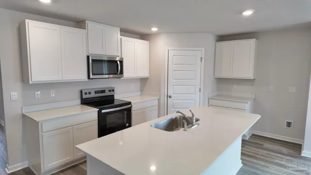 a kitchen with a appliances a sink and a microwave