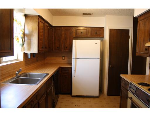 3305 Meadow Ridge Drive Corpus Christi, TX 78418 - Photo 7 of 9 a kitchen with refrigerator a counter and cabinets