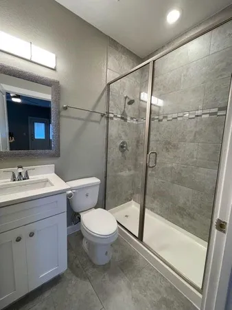 a bathroom with a granite countertop sink toilet and shower